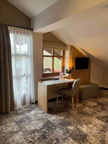 a room with a desk and a chair and a window at Appartment-Hotel-Hölzl in Grünwald