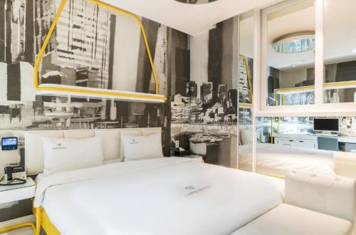 a bedroom with a white bed and a black and white picture at Zara Hotel Peace Square in Mokpo