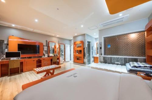 a large room with a bed and a television at Zara Hotel Peace Square in Mokpo