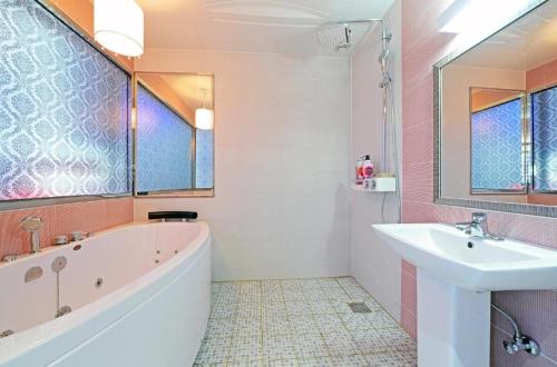 a bathroom with a tub and a sink at Zara Hotel Peace Square in Mokpo
