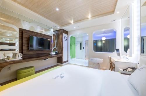 a bedroom with a large bed and a television at Zara Hotel Peace Square in Mokpo