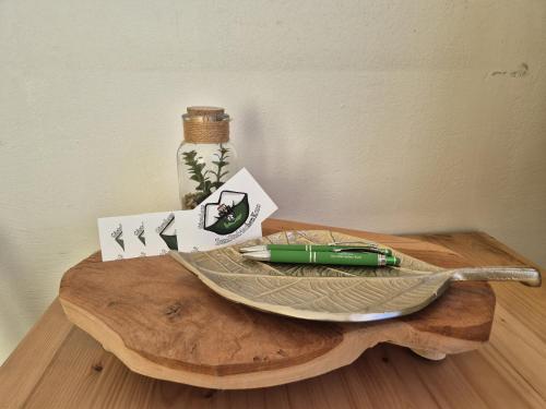 a green pen sitting on top of a wooden table at Gästehaus Zum Steirischen Kuss in Aich