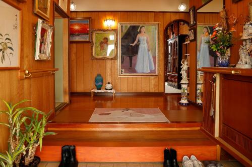 a hallway with a painting of a woman on the wall at つるのやど 