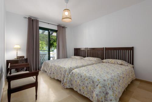 Un dormitorio con una cama y una silla y una ventana. en Villa Bali, en Manilva