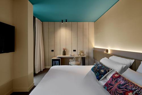 a bedroom with a white bed with a blue ceiling at WANDERLUST HOTEL - SUITE & SPA - APARTMENTS & VILLAS - Bardolino, Lago di Garda - Verona in Bardolino