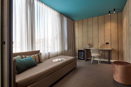 a living room with a couch in front of a window at WANDERLUST HOTEL - SUITE & SPA - APARTMENTS & VILLAS - Bardolino, Lago di Garda - Verona in Bardolino