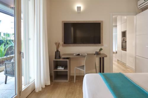 a bedroom with a desk and a television on a wall at WANDERLUST HOTEL - SUITE & SPA - APARTMENTS & VILLAS - Bardolino, Lago di Garda - Verona in Bardolino