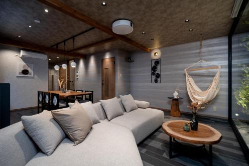 a living room with a white couch and a table at JAPAVISTA Toan in Osaka