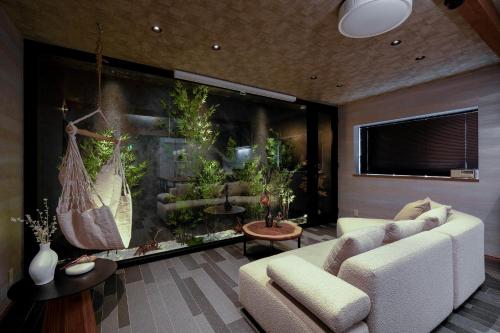 a living room with a couch and an aquarium at JAPAVISTA Toan in Osaka