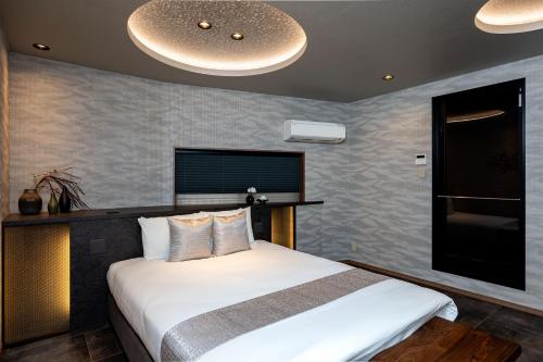 a bedroom with a large white bed in a room at JAPAVISTA Toan in Osaka