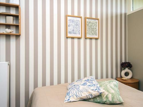 a bedroom with striped walls and a bed with a pillow at 4 star holiday home in Fanø in Fanø