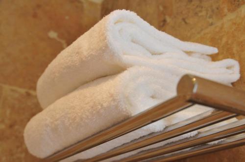 a pile of white towels on a towel rack at Les Glycines Vézelay in Vézelay