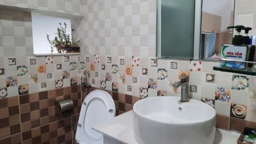 a bathroom with a sink and a toilet at NEST House in Ấp Kim Thạch