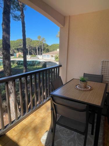 une table et des chaises sur un balcon avec vue dans l'établissement Appartement Piscine et pinede - Wifi, à Saint-Raphaël