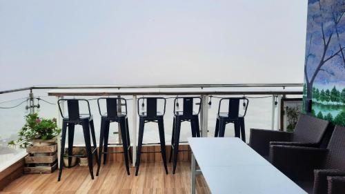 a group of chairs and tables on a balcony at NEST House in Ấp Kim Thạch