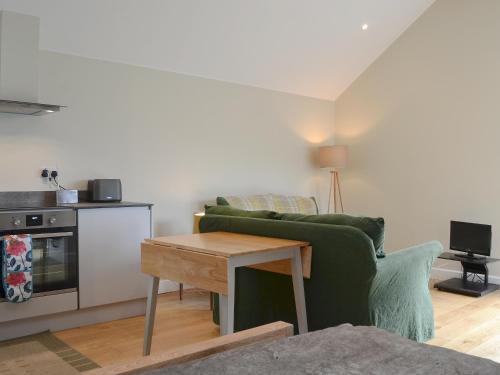 a living room with a green couch and a table at Cottam Road in Threlkeld