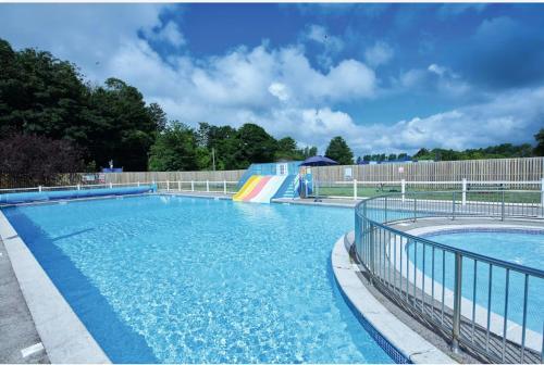 a large swimming pool with a ramp and a slide at The Puffins Rest in Tenby