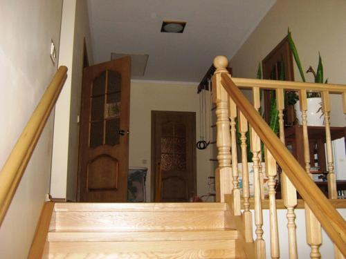 a wooden staircase with a wooden door in a house at Saulesdarzs in Ragaciems