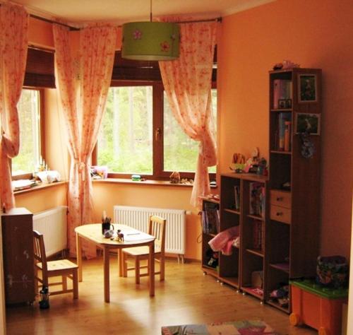 a living room with a table and a window at Saulesdarzs in Ragaciems