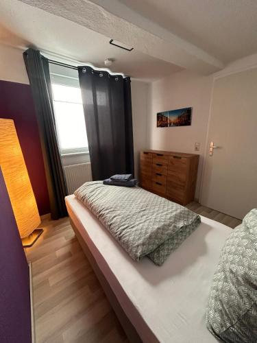 a bedroom with a bed and a dresser and a window at Schönes 4-Zimmer Appartment, WLAN, Küche, BAD in Ilmenau