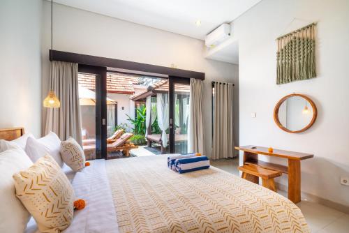 Un dormitorio con una cama, una mesa y un espejo. en Villa O'Anne II, en Seminyak