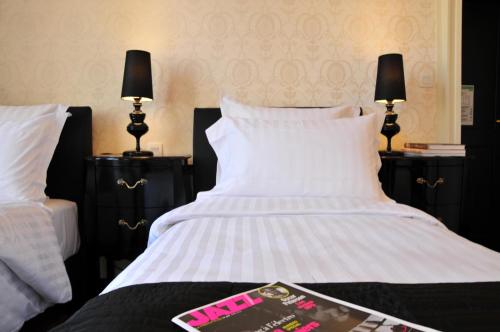 a bedroom with a white bed with two lamps at Les Glycines Vézelay in Vézelay
