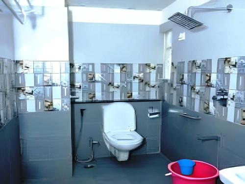a bathroom with a white toilet in a stall at Palani Andavar in Bangalore