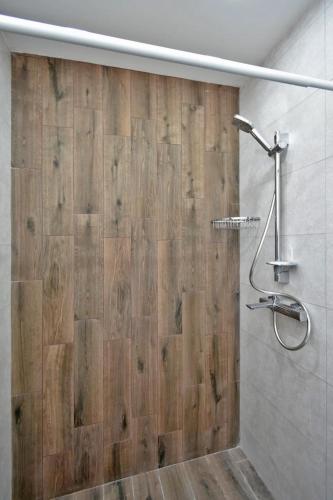 a bathroom with a shower with a wooden wall at Komitas Comfort and Charm in Yerevan