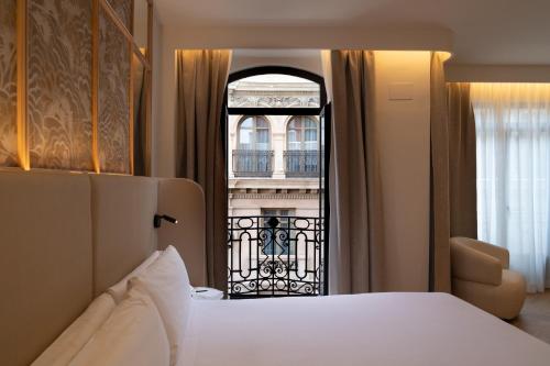 a hotel room with a bed and a window at Petit Palace Chueca in Madrid