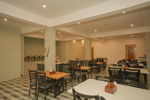 a restaurant with tables and chairs in a room at The Himalayan Stories - A Riverside Heaven Resort in Vashisht