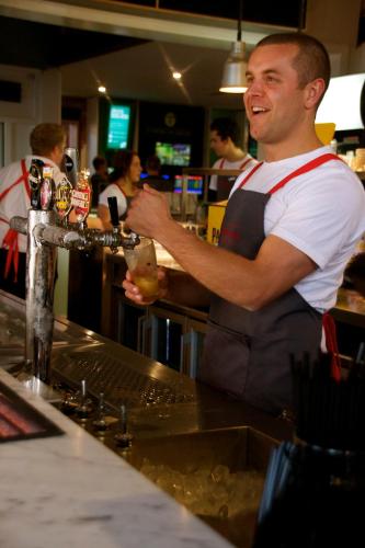 a man standing at a bar preparing a drink at Western Hotel Ballarat in Ballarat