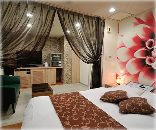 a bedroom with a large bed and a kitchen at HOTEL TWO in ONE Hiroshima-AdultOnly in Hiroshima