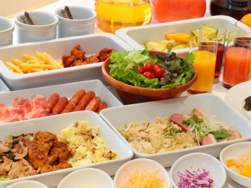 a table topped with trays of different types of food at Hotel Dans Le Coeur Osaka Umeda in Osaka