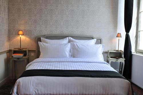 a bedroom with a large bed with white pillows at Les Glycines Vézelay in Vézelay