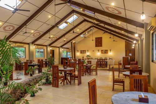 a restaurant with tables and chairs in a room at WilderNest Araanya by Vibescapes in Karjat