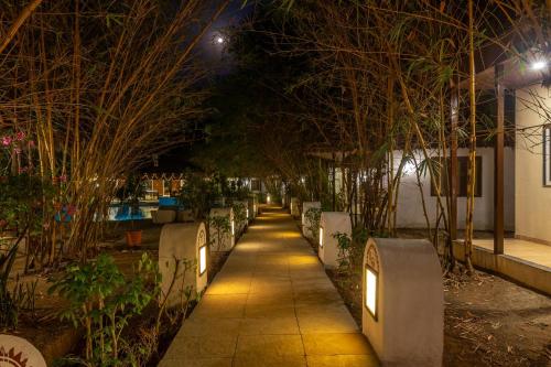 a sidewalk with lights on it at night at WilderNest Araanya by Vibescapes in Karjat