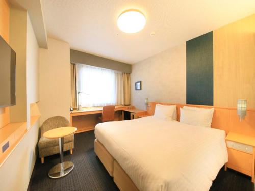 a hotel room with a large bed and a desk at Richmond Hotel Yamagata Ekimae in Yamagata