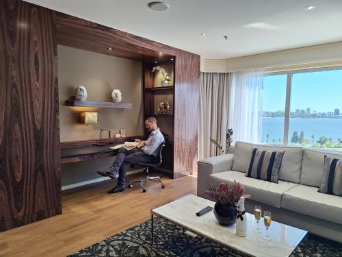 a man sitting at a desk in a living room at Residence on Langley Park in Perth