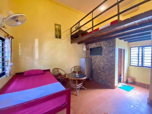 a bedroom with a bed and a loft at Derm Svay Guesthouse - yoga & cafe in Kampot