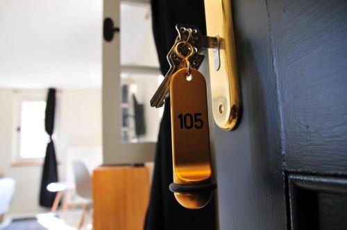 a key hanging from a door with a house tag at Les Glycines Vézelay in Vézelay