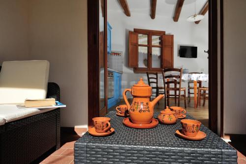 Villa Maddalena في بوناي: طاولة عليها أكواب وقدر شاي