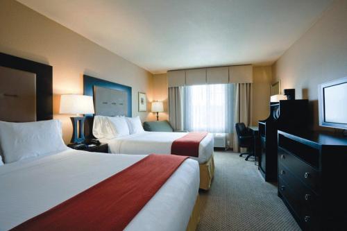a hotel room with two beds and a flat screen tv at Holiday Inn Express Portland East - Columbia Gorge by IHG in Troutdale