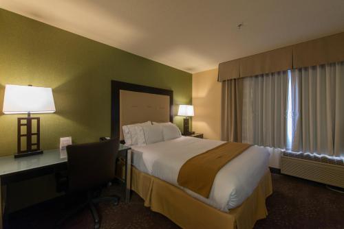 a hotel room with a bed and a desk with a computer at Holiday Inn Express Portland East - Columbia Gorge by IHG in Troutdale