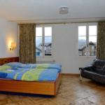 a bedroom with a bed and two windows at Residence Jungfrau in Interlaken
