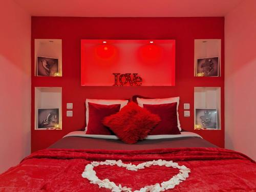 a red bedroom with a bed with a heart on it at Love Room Perpignan Jacuzzi & Ambiance romantique in Villeneuve-de-la-Raho