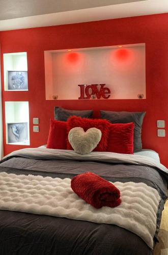 - une chambre rouge avec un lit avec un cœur dans l'établissement Love Room Perpignan Jacuzzi & Ambiance romantique, à Villeneuve-de-la-Raho