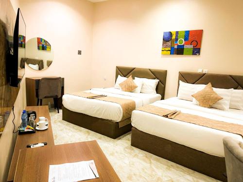 a hotel room with two beds and a table at City King Hotel in Kano