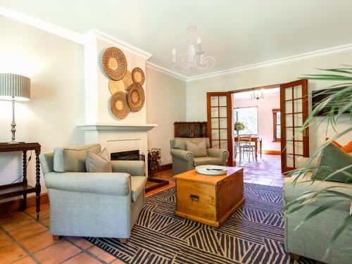 a living room with two chairs and a fireplace at Keerweder Cottages in Franschhoek
