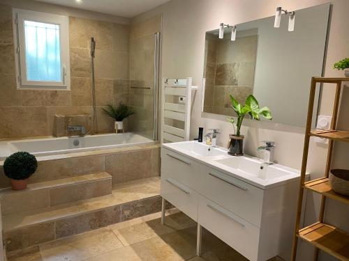 La salle de bains est pourvue d'un lavabo blanc et d'une baignoire. dans l'établissement Le Secret des Pins, à Pernes-les-Fontaines