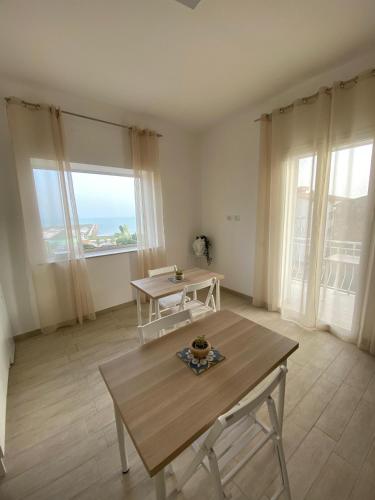a living room with a table and a large window at La Casa di Sara in Porto Empedocle